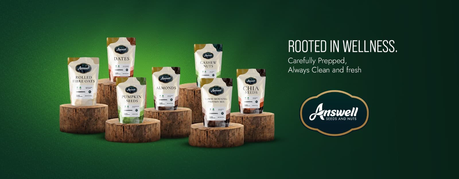 Answell pouches on wooden stumps: rolled fibre oats, dates, pumpkin seeds, almonds, cashew nuts, good morning protein mix and chia seeds. Rooted in wellness.